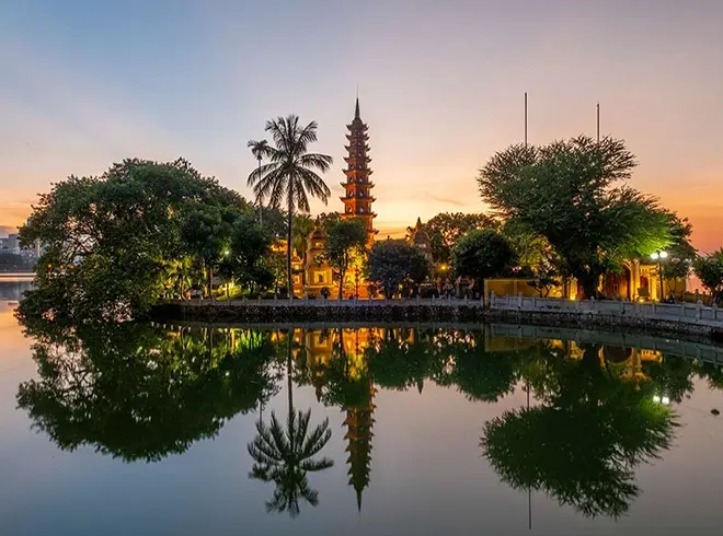 Tran Quoc Pagoda reflecting on West Lake at sunset in Hanoi