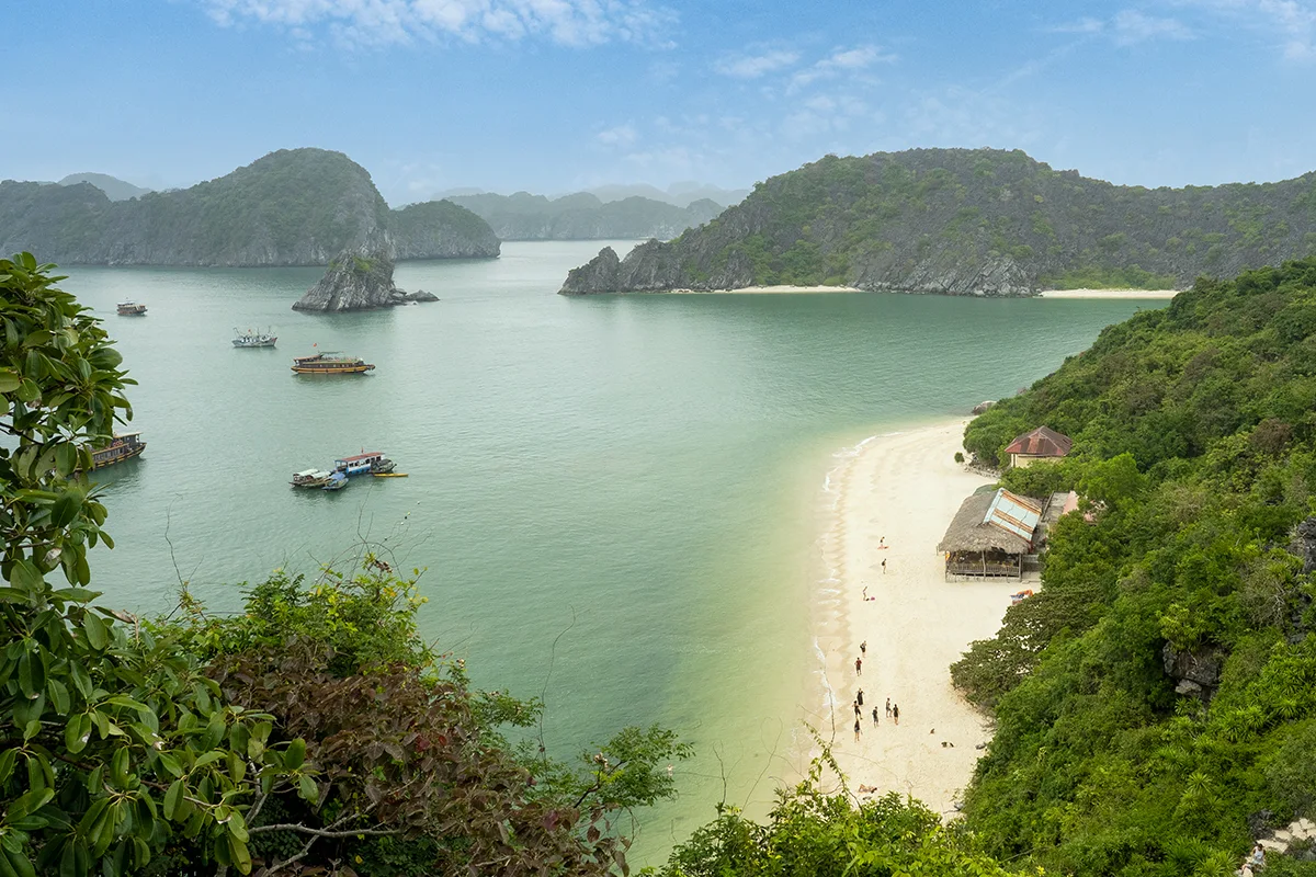 Elevated view of a Lan Ha Bay beach, karsts, and boats.