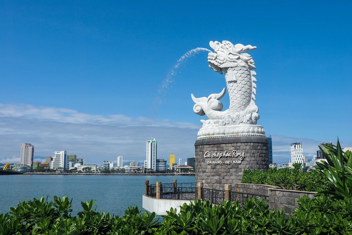 White dragon carp statue spraying water against Da Nang's blue sky