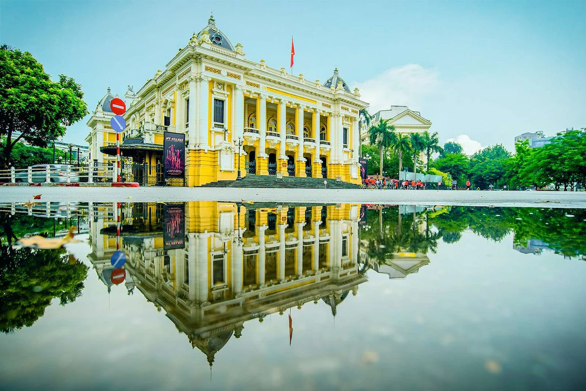 Hanoi Opera House's yellow French colonial facade reflected in water
