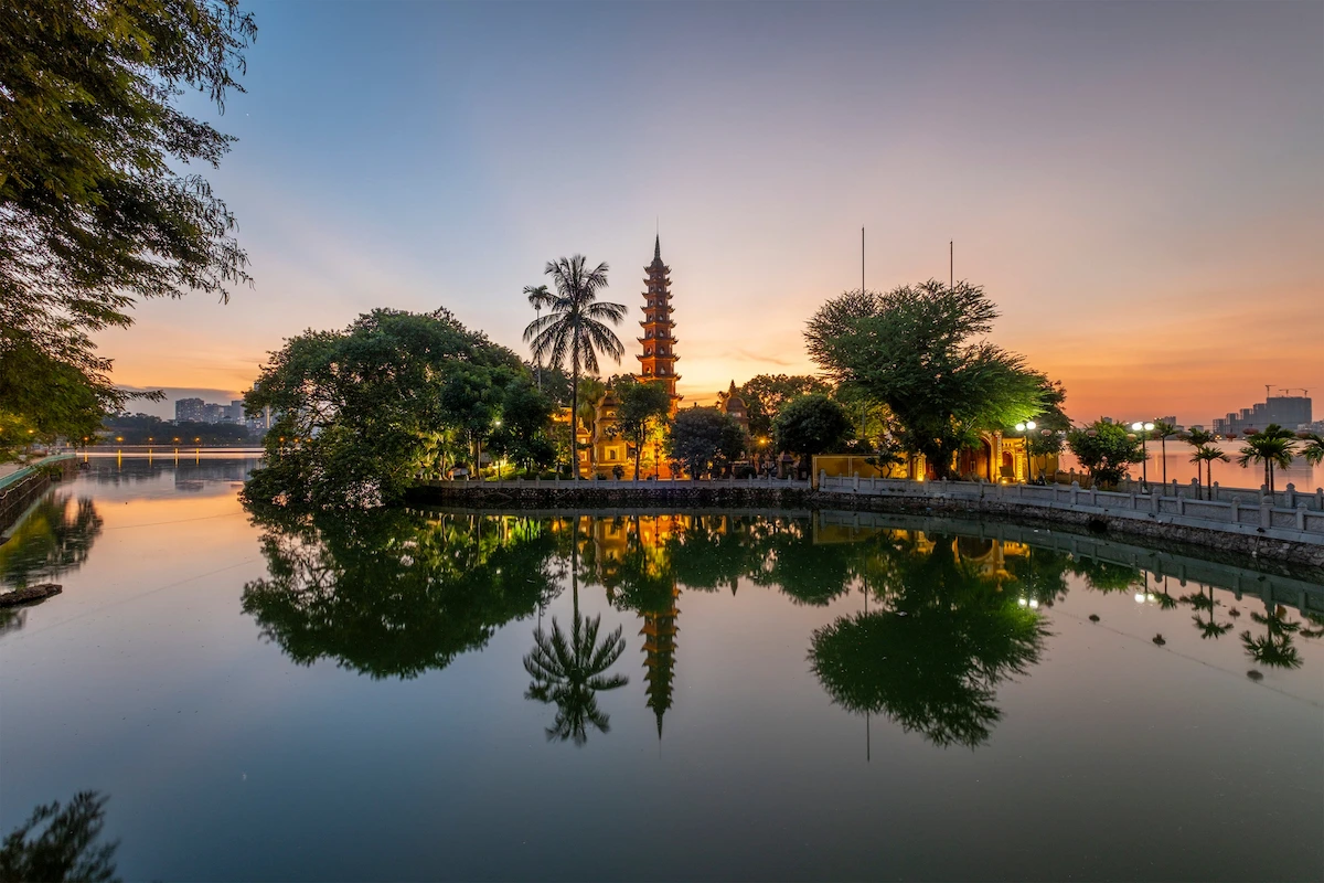 Tran Quoc Pagoda reflected in West Lake at sunset in Hanoi