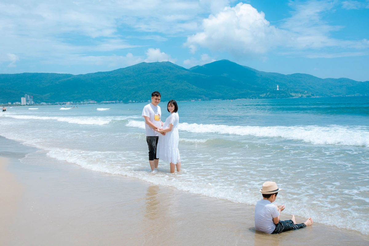 Couple standing in shallow turquoise water at My Khe Beach